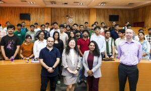 A large group of smiling staff members posing together for a group photograph.