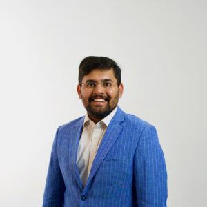 Student in a blue blazer smiling at the camera.