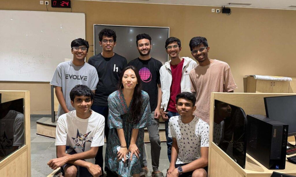 Group of students posing and smiling for a photo inside a classroom.